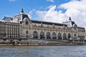 Historic waterfront building with ornate architecture, large arched windows, and clock towers.