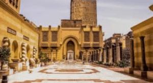 Urban courtyard with classical architecture, yellow-tinted walls, archways, and decorative columns.