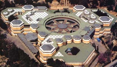 Aerial view of a modern multi-story building with central circular structure and hexagonal units