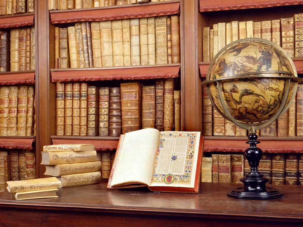 Antique library with leather-bound books, a decorated open book, and an illustrated globe on a table.
