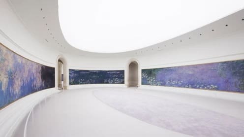 Curved gallery room with panoramic paintings on white walls and a spacious floor.