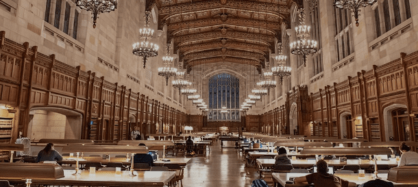 Expansive library interior with chandeliers, arched windows, wooden tables, and ornate details.