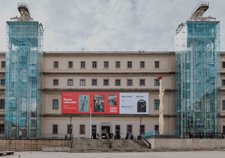 Exterior of a large historic building with exhibitions, glass elevators, and a front sculpture.
