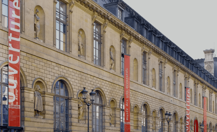 Historic building with arched windows and statues, banners indicate it is Musée des Arts Décoratifs.