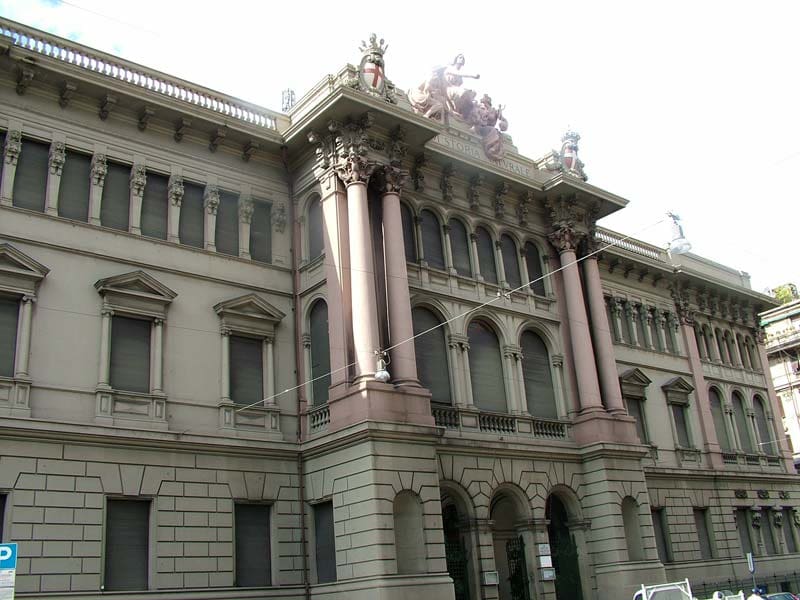 Historic building with classical architecture featuring columns, ornate sculptures, and rectangular windows.