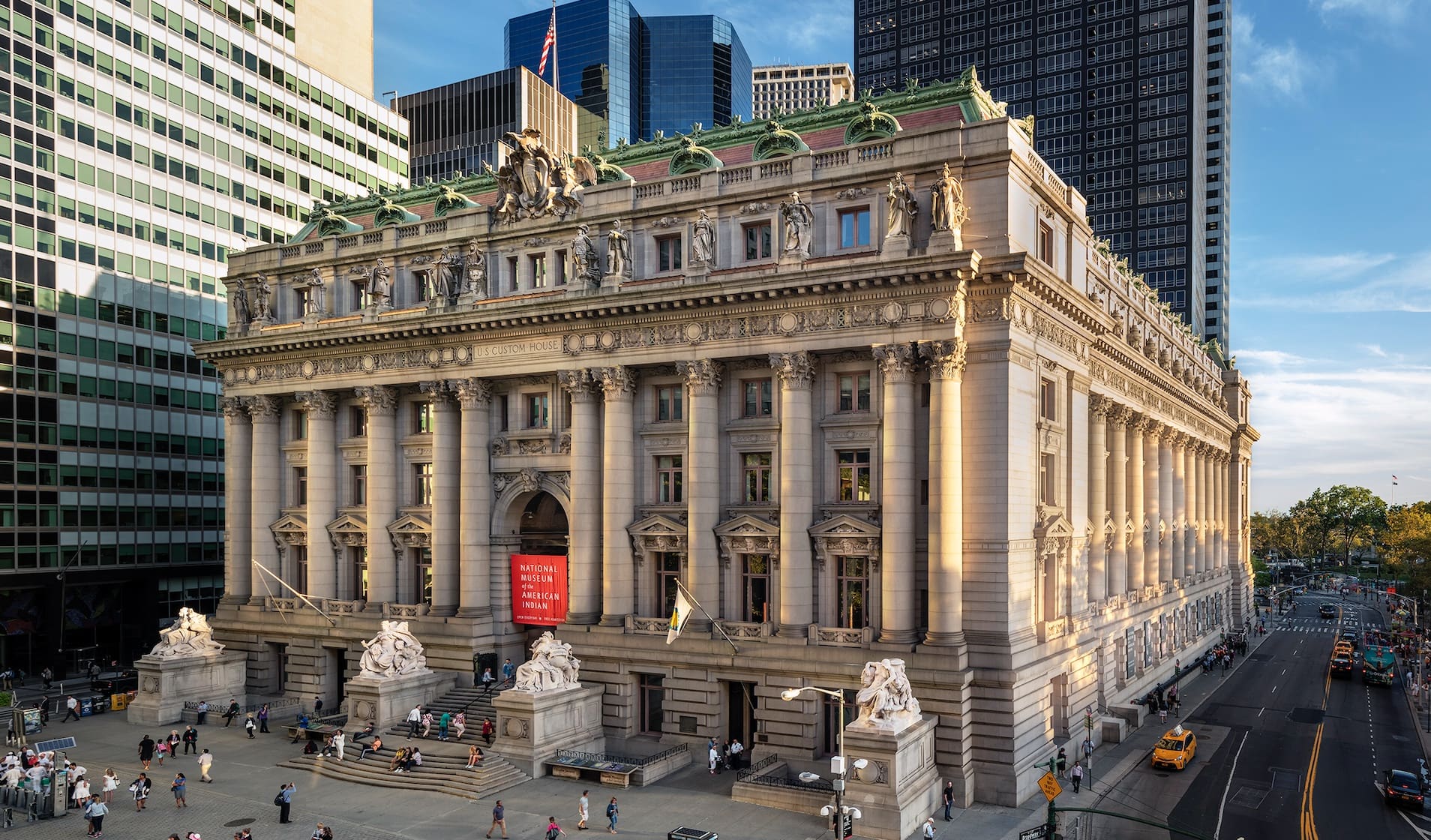 Historic U.S. Custom House with columns and statues, home to the National Museum of the American Indian.