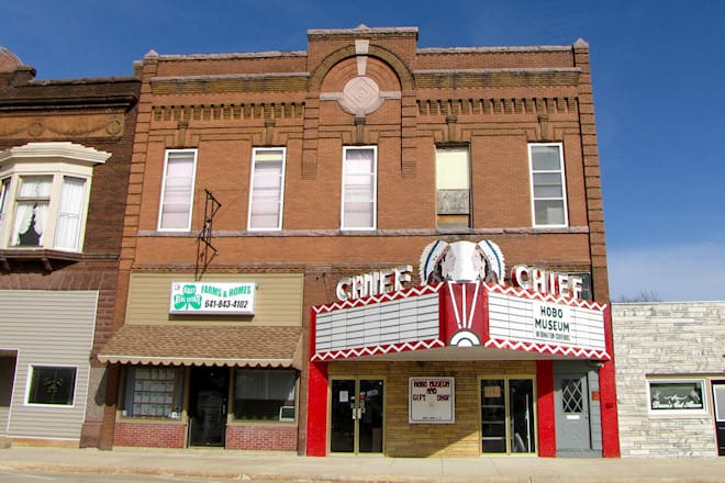 Brick building with a marquee sign for "Hobo Museum," flanked by windows and additional signage.
