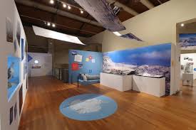 Indoor museum exhibit on Antarctic exploration, featuring display cases, panels, and polar landscapes.