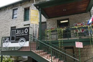 Stone building with green metal staircase, signs for Jell-O museum in LeRoy, birthplace of Jell-O.