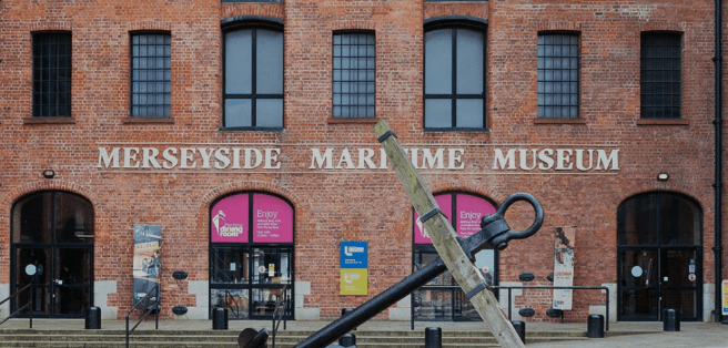 Merseyside Maritime Museum in a brick building with large windows and an anchor in the front.