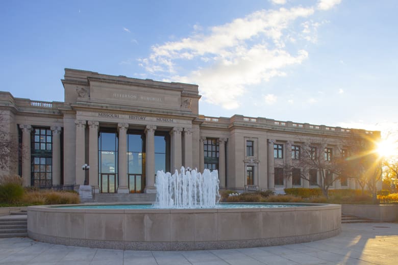 Missouri History Museum building with tall columns, "Jefferson Memorial" inscription, and front fountain.