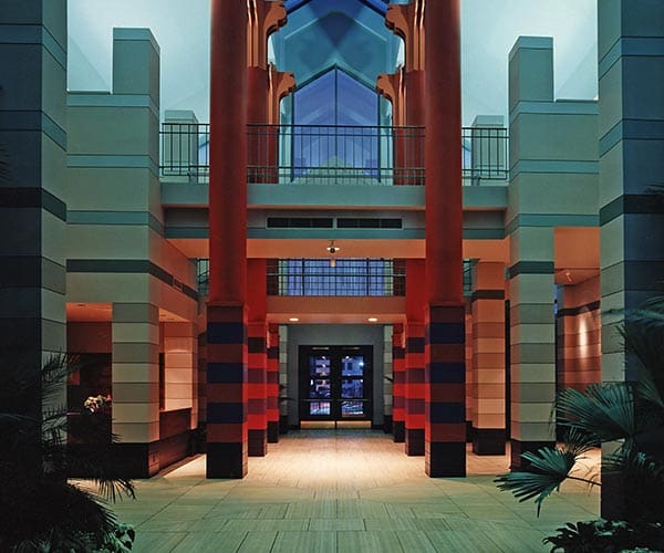 Modern interior with red and dark blue columns, geometric skylight, and clean design lines.