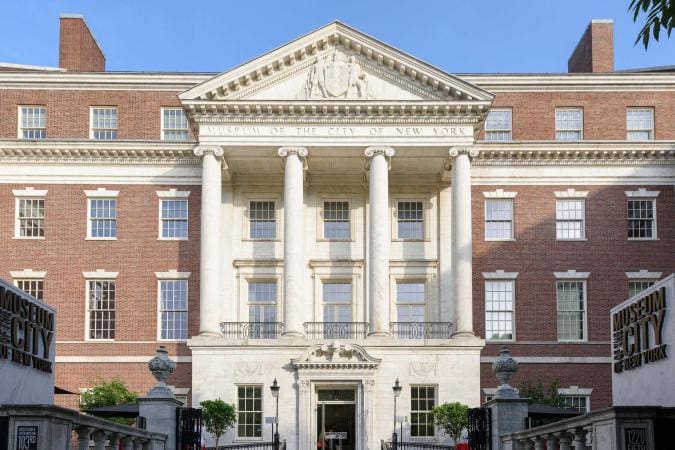 Exterior view of the Museum of the City of New York, a red-bricked building with classical columns.