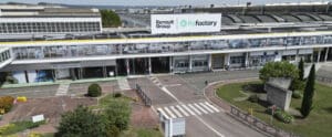 Modern industrial facility labeled "Renault Group ReFactory," with glass paneling and landscaped areas