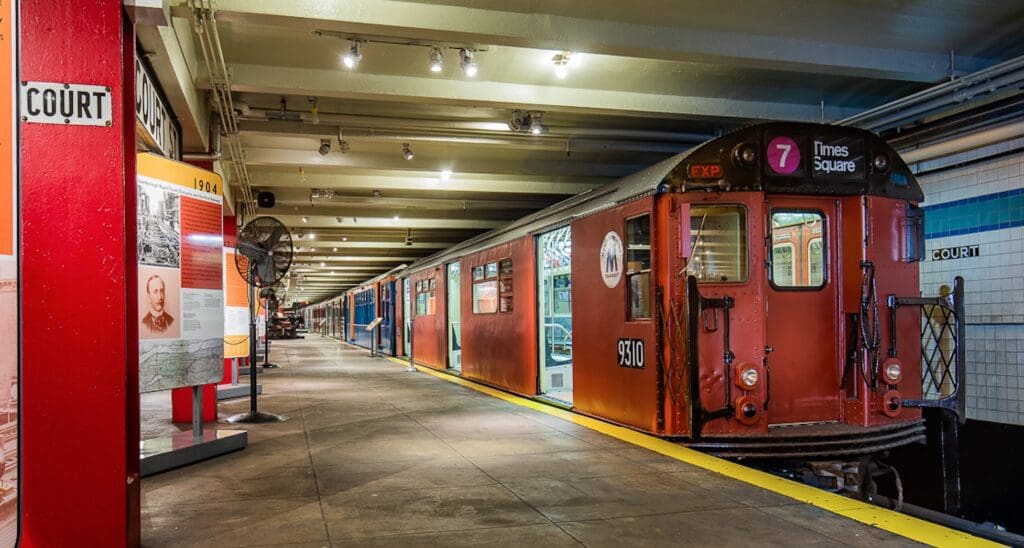 Vintage red subway train car at Court platform with historical transit displays, dated 1904.