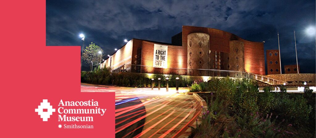 Anacostia Community Museum at night with "A Right to the City" banner and surrounding greenery.