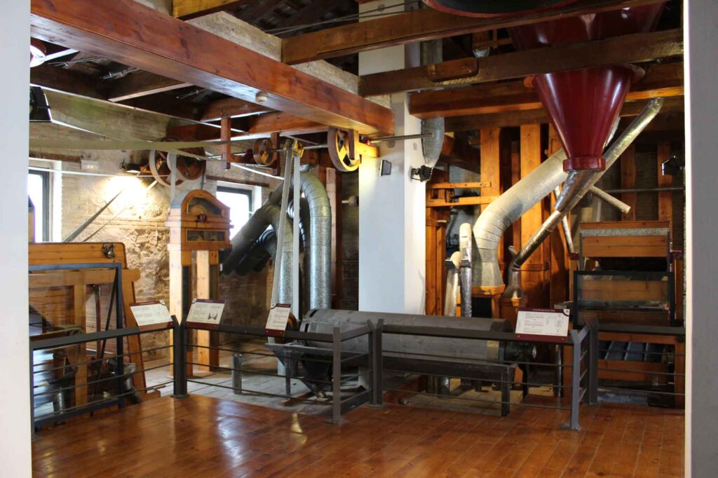 Interior of an industrial museum exhibit with historical machinery and informational plaques.