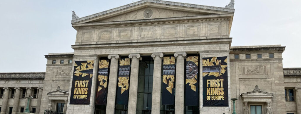 Neoclassical building with columns displaying "First Kings of Europe" exhibition banners.