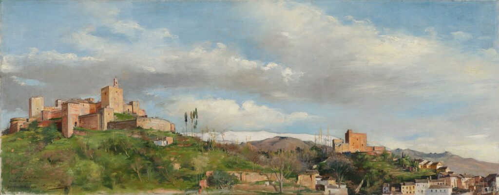 Historic fortress on a hill in a lush landscape with mountains and a partly cloudy sky.