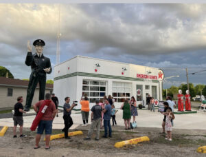 Group outside American Giants Museum with vintage gas pumps, large statue, and retro Texaco sign.