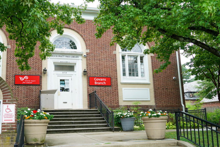 Govans exterior entrance doors steps flowers red signs 768x512