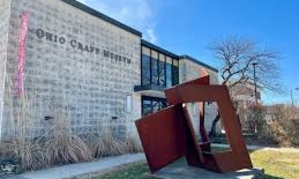 Exterior of Ohio Craft Museum with large windows, brick facade, abstract sculpture, and clear sky